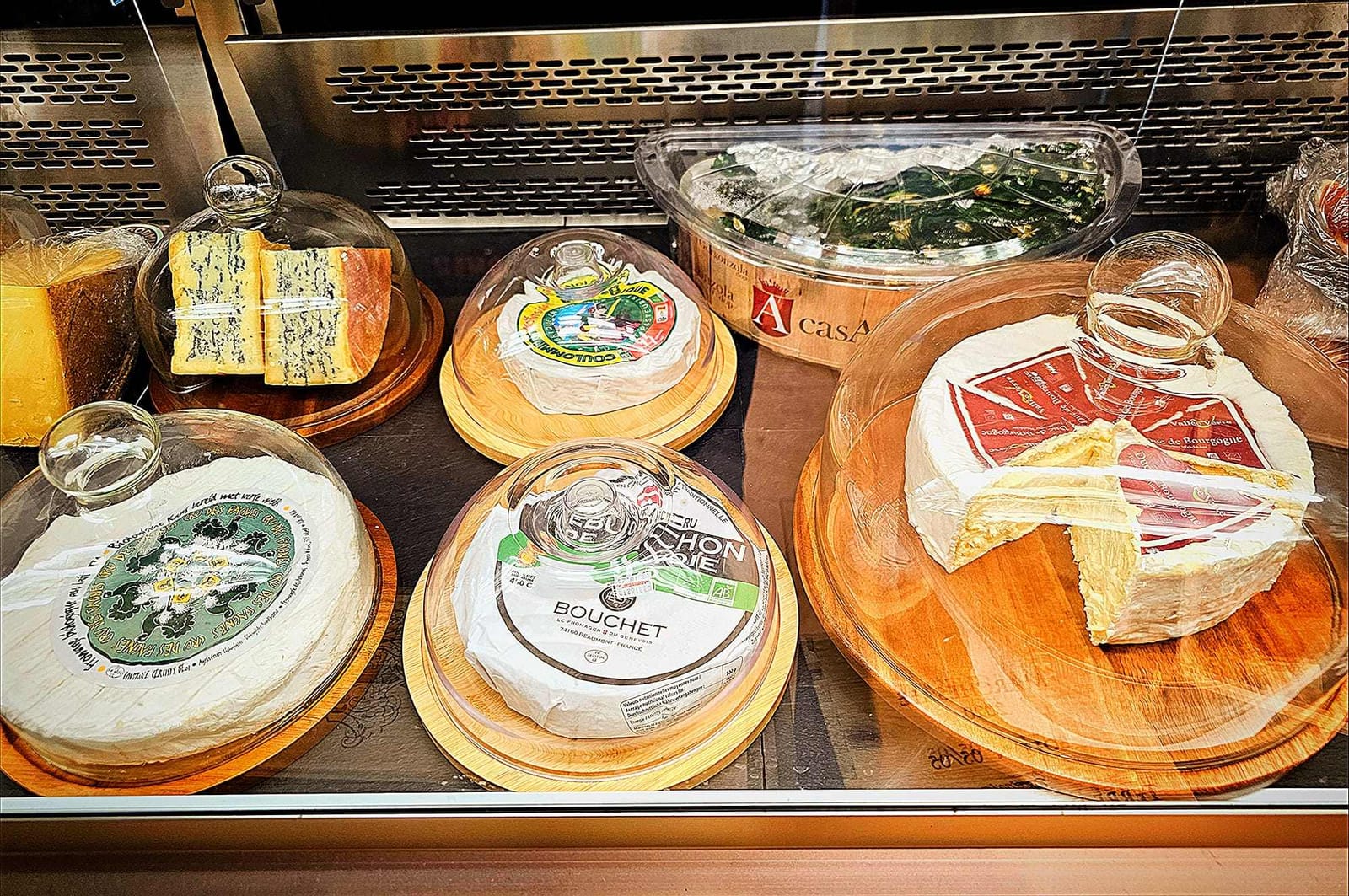 Weichkäse unter Glasglocken in der Käsetheke